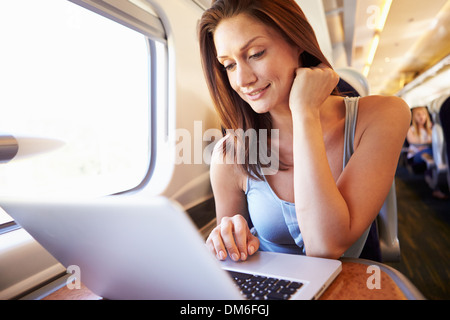 Woman Using Laptop On Train Stock Photo