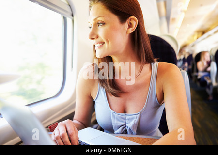 Woman Using Laptop On Train Stock Photo