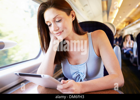 Woman Using Digital Tablet On Train Stock Photo