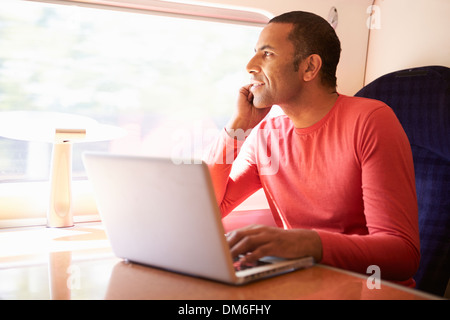 Man Using Laptop On Train Stock Photo