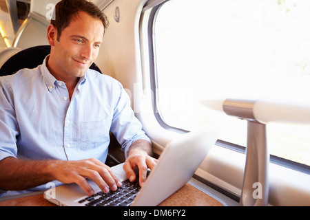 Man Using Laptop On Train Stock Photo