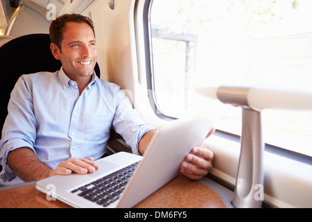 Man Using Laptop On Train Stock Photo