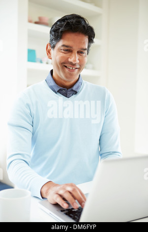 Indian Man Using Laptop At Home Stock Photo