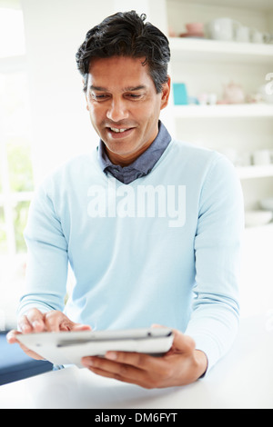 Indian Man Using Digital Tablet At Home Stock Photo