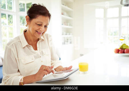 Senior Indian Woman Using Digital Tablet At Home Stock Photo