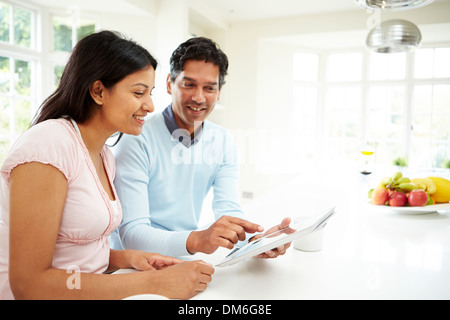 Indian Couple Using Digital Tablet At Home Stock Photo