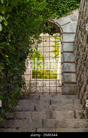 Stone gate locked with rusted steel grating Stock Photo
