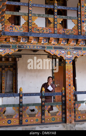 Bhutan, Bumthang Valley, Bhutanese man amongst of Nunnery decorative painted wooden structure Stock Photo