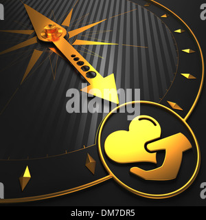 Golden Icon of Heart in the Hand on Compass. Stock Photo