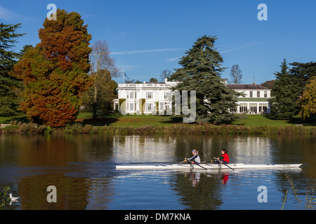 England, Buckinghamshire, autumn, rowers on river Thames, with Henley management college Stock Photo