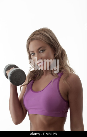 Woman in gym clothes holding dumbbells doing a work out Stock Photo