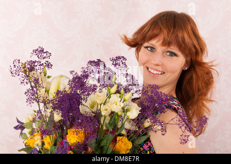 Portrait of woman in interior with colorful bouquet flowers Stock Photo
