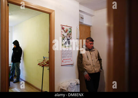 Madrid, Spain. 11th Dec, 2013. 34-year-old John Jairo Nanez Betancur from Colombia lies at the front door of his home while at the other room Jose Arcilla speaks to the telephone as they wait to be evicted in Madrid, Spain, Wednesday, Dec. 11, 2013. John Nanez Betancur became unemployed after losing his job. He bought a euro 213.000 ($ 291.360) apartment by taking a mortgage with Bankia bank in 2005 but stopped paying due to his financial situation in 2010. He lived in the apartment with Jose Arcila 50 years old, his wife Betsi Ojeda, 33 years old, both unemployed, and Betsi's daughter, Nico Stock Photo