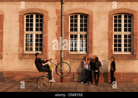 Elk213-2697 France, Alsace, Colmar, teen boy on bike doing wheelie for girls Stock Photo