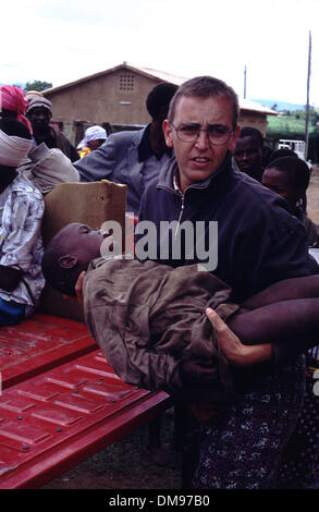 Apr 08, 1994 - Burundi, Rwanda - Young wounded child is carried by MSF doctor as Rwandan Tutsi refugees flee across the border into Burundi in April 1994 as the Hutus commited genocide in a 100 day civil warr. The Rwandan Genocide was the 1994 mass murder of an estimated 800,000 people in the small East African nation of Rwanda. Over the course of approximately 100 days from the as Stock Photo