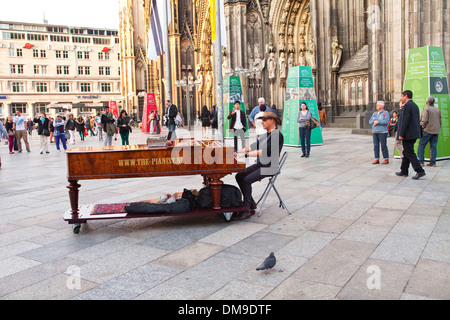 A man plays the piano in front of Cologne cathedral. Stock Photo