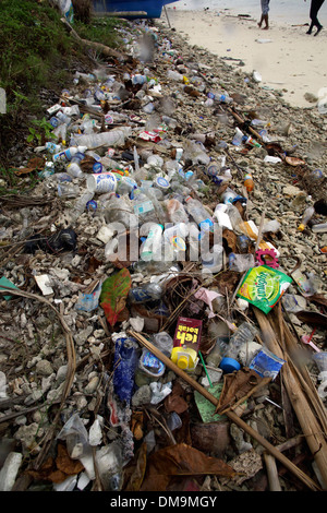 Garbage pile of plastic bottles and other debris washed up onto hide tide line on tropical beach in Manokwari Harbor Stock Photo