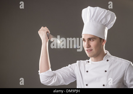 Portrait of smiling chef with in hand isolated on grey background Stock Photo