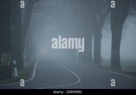 Motzen, Germany. 13th Dec, 2013. A car drives through the morning fog near Motzen, Germany, 13 December 2013. Berlin was shrouded in thick fog Friday morning. Photo: BERND VON JUTRCZENKA/dpa/Alamy Live News Stock Photo