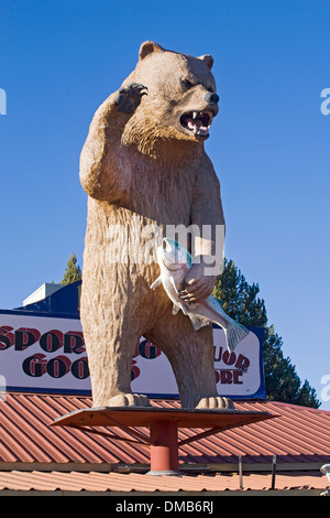 A grizzly bear with a salmon atop a sporting goods store in Gilchrist, Oregon Stock Photo