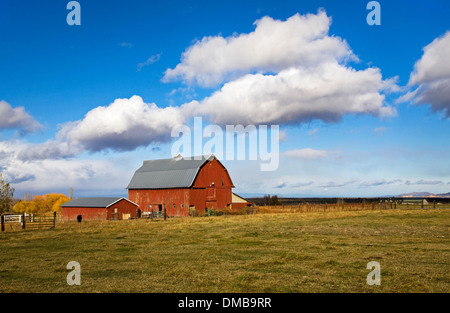 An old red barn and fluffy clouds on a farm in central Oregon. Stock Photo