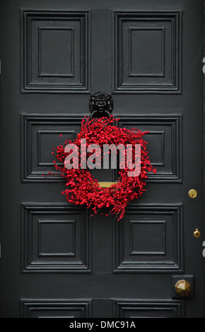 Christmas wreath hanging on front door of  traditional English country home, Ashford-in-the-Water, Peak District, Derbyshire Stock Photo