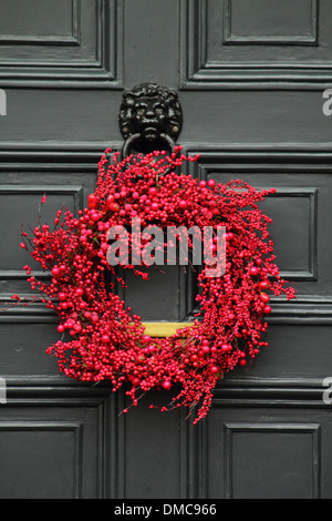 Christmas wreath hanging on front door of  traditional English country home, Peak District, Derbyshire Stock Photo