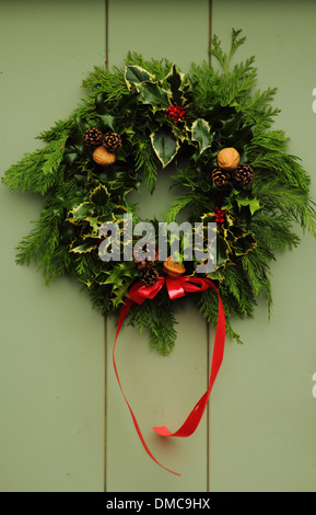 Christmas wreath hanging on front door of traditional English country home, Peak District, Derbyshire Stock Photo