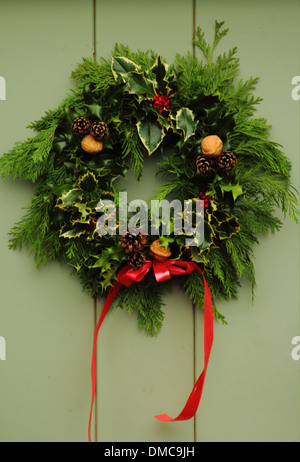 Christmas wreath hanging on front door of  traditional English country home, Peak District, Derbyshire Stock Photo