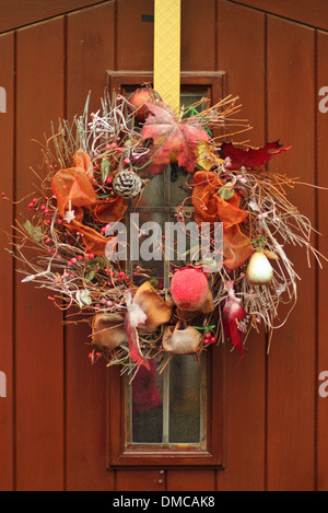 A autumnal garland hanging on the  front door of traditional country home in an English village Stock Photo