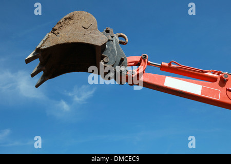 Raised scoop of an excavator over blue sky Stock Photo