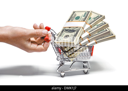 Hand pulling shopping cart full of stacks of dollar bills Stock Photo