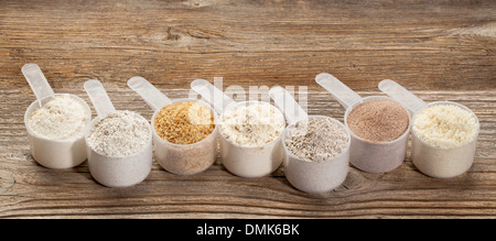 a row of measuring scoops of gluten free flours - almond, coconut, teff, flaxseed meal, whole rice, brown rice, buckwheat Stock Photo