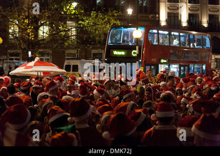 London, UK. 14th of December 2013 Hundreds of revelers of the annual Santa Con event, gathered outside BBC Broadcasting House in Portland Place. They sung and danced to mobile music players spreading their Christmas cheer to passers by. Police officers arrived to ensure the road was clear. Credit:  nelson pereira/Alamy Live News Stock Photo