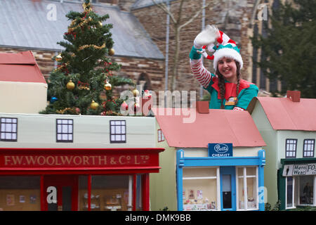 Wimborne, Dorset UK Saturday 14 December 2013. Crowds turn out to watch the 25th Wimborne Save The Children Christmas Parade. Young woman girl dressed up on float with Wimborne model town, miniature Stock Photo