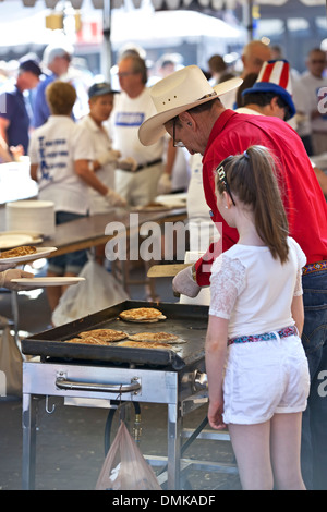 Man and little girl making pancakes, Pancakes on the Plaza 4th of July Celebration, Santa Fe, New Mexico USA Stock Photo