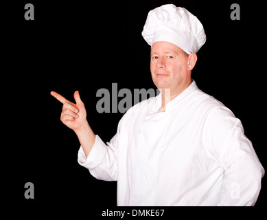 Male chef pointing on isolated black background Stock Photo