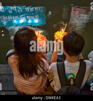 Friends gather to release floating offerings during Loy Kratong festival in Bangkok, Thailand Stock Photo