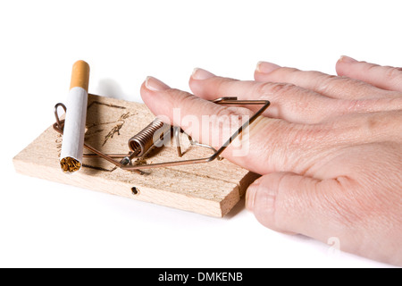 Hand attempting to remove money from large mouse trap Stock Photo