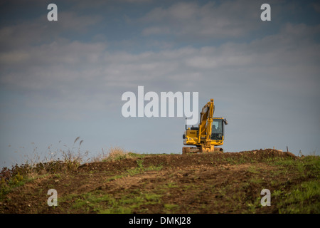 A yellow excavator sits atop a hill in Odawara, Yokohama, Japan on 08 November 2013. Stock Photo