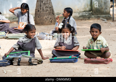 Rural Indian village school children in an outside class writing on a chalk tablets. Andhra Pradesh, India Stock Photo