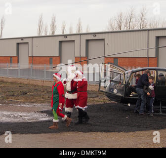 Leyland, Preston, Lancashire, UK. 15th Dec 2013. Santas elves escorting Santa to meet the children and parents awaiting his arrival. Credit:  Sue Burton/Alamy Live News Stock Photo