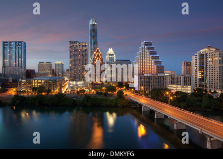 The Austin skyline in the evening glows in the evening light. The reflections of the highrises are reflected in the water. Stock Photo