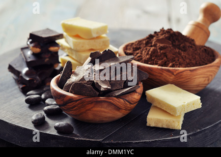 Chocolate pieces with cocoa beans and cocoa powder on wooden background Stock Photo
