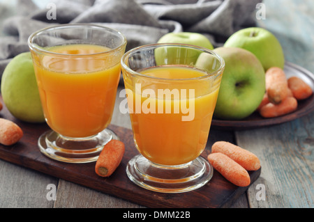 Apple and carrot juice in glass with fresh vegetables and fruits on wooden background Stock Photo