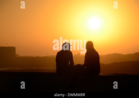 Lovers sitting on the wall at Skala du Port close to Medina Essaouira Morocco Stock Photo