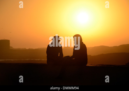 Lovers sitting on the wall at Skala du Port close to Medina Essaouira Morocco Stock Photo