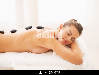 Portrait of relaxed young woman receiving hot stone massage Stock Photo