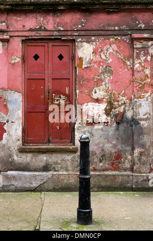 Window and shutters of a peeling and dilapidated looking house in Princelet Street, Spitalfields. Stock Photo