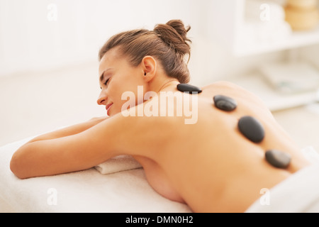 Young woman receiving hot stone massage Stock Photo